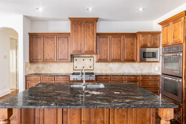a kitchen with granite countertop wooden cabinets and a granite counter tops