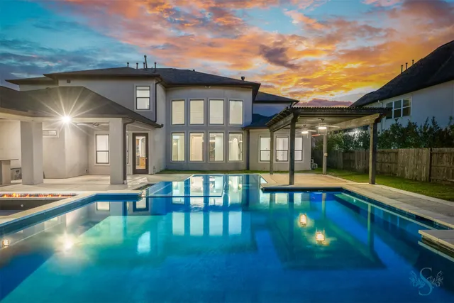 a view of a house with swimming pool and sitting area