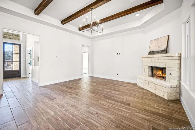 a view of empty room with wooden floor and fireplace