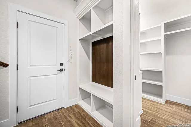 a view of a hallway with wooden floor and closet