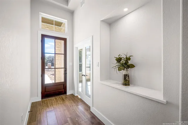 a view of a hallway with wooden floor and a window