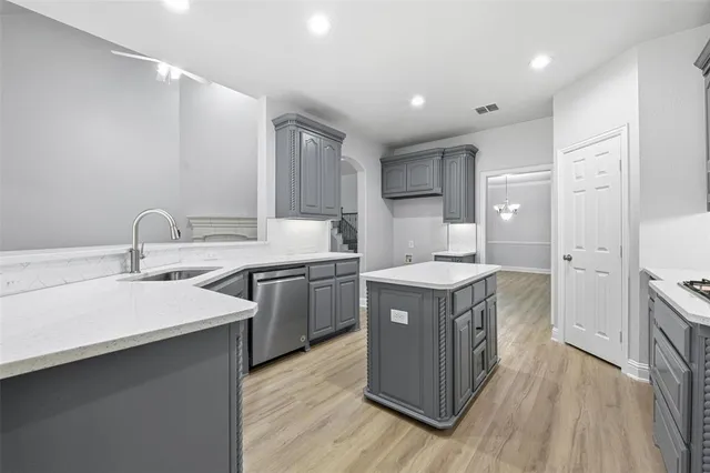a kitchen with a stove sink and cabinets