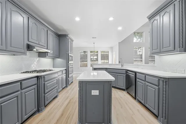 a kitchen with stainless steel appliances granite countertop a sink stove and cabinets