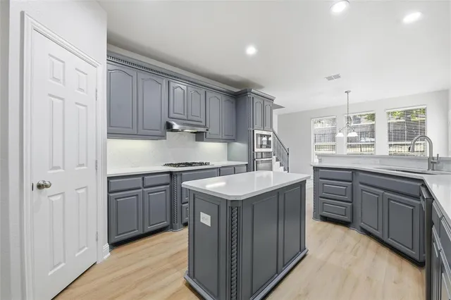 a kitchen with a sink stove and cabinets