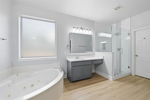 a bathroom with a tub sink and mirror