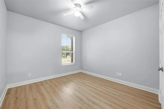 wooden floor in an empty room with a window