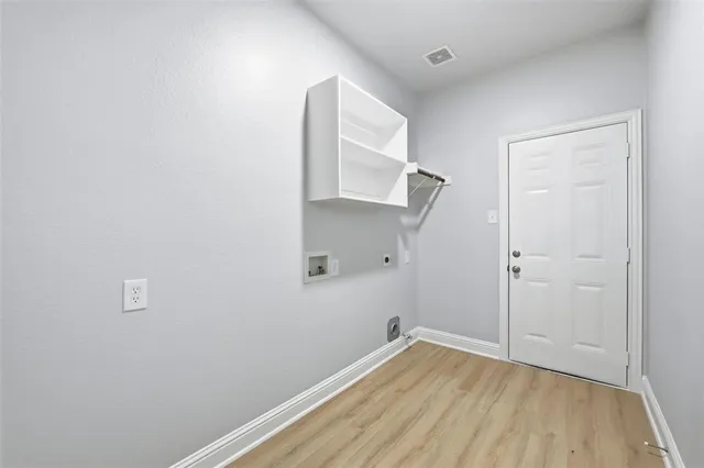 a view of room with walk in closet and wooden floor
