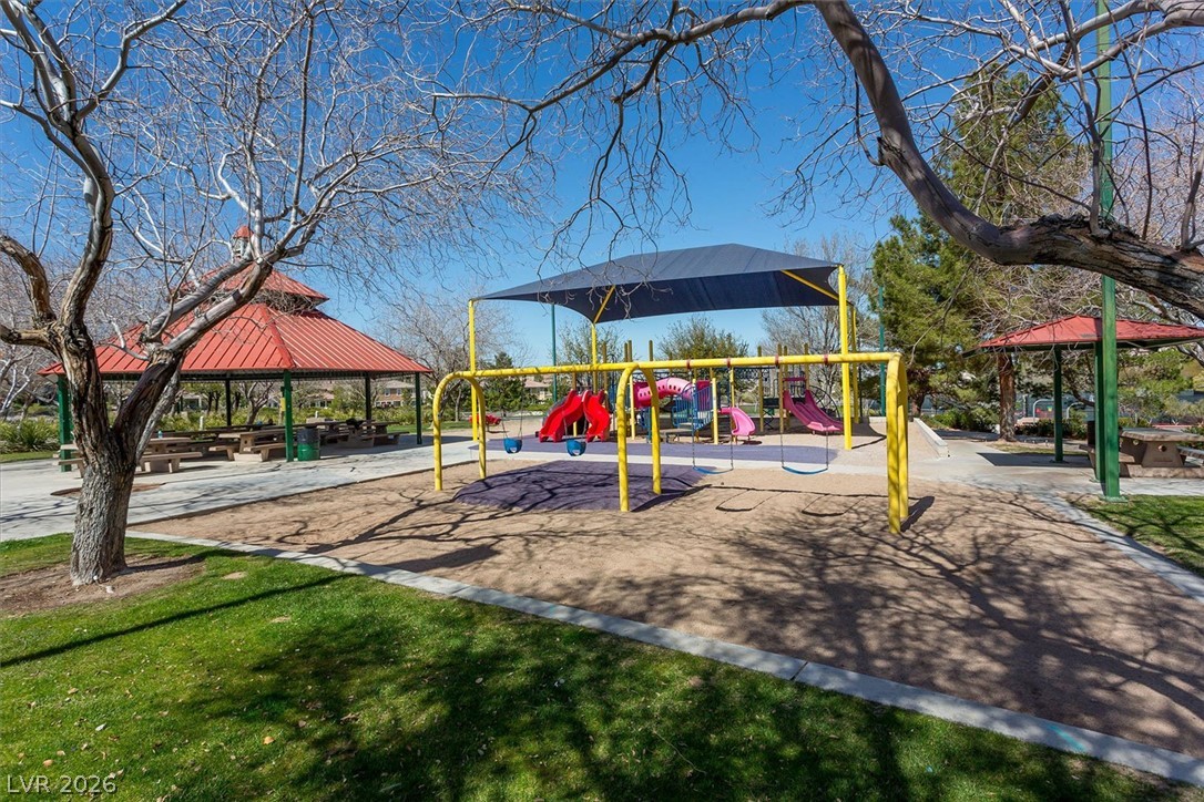 1259 Moon Vision Street Henderson, NV 89052 - Photo 45 of 53 A vibrant playground set amidst green grass, perfect for family enjoyment.