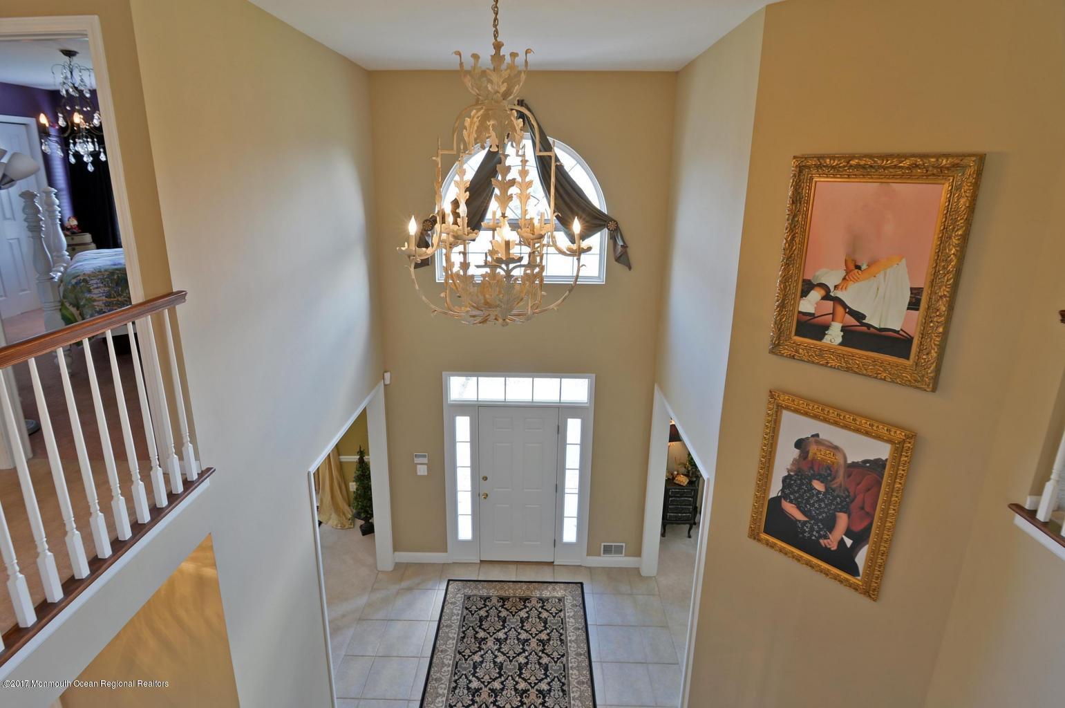 8 Rodeo Drive Jackson, NJ 08527 - Photo 20 of 54 a view of a hallway with wooden floor and a chandelier