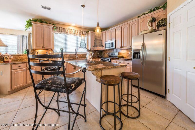 8 Rodeo Drive Jackson, NJ 08527 - Photo 9 of 54 a kitchen with stainless steel appliances kitchen island granite countertop a table chairs stove and refrigerator