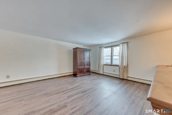 an empty room with wooden floor and chandelier