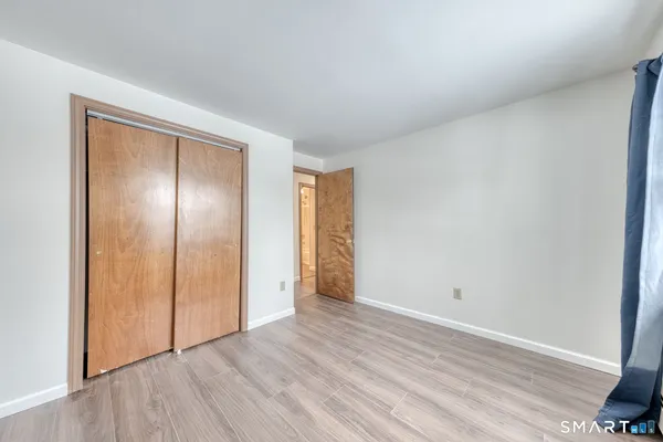 an empty room with wooden floor & windows