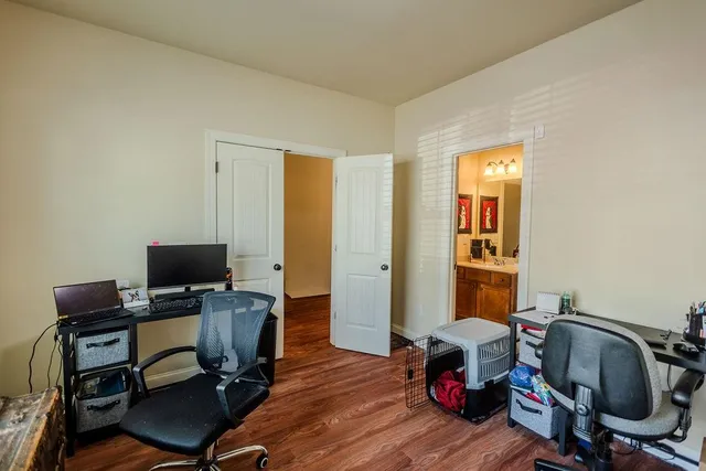 a view of a workspace with furniture and a window
