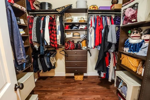 a view of walk in closet with clothes and shoes