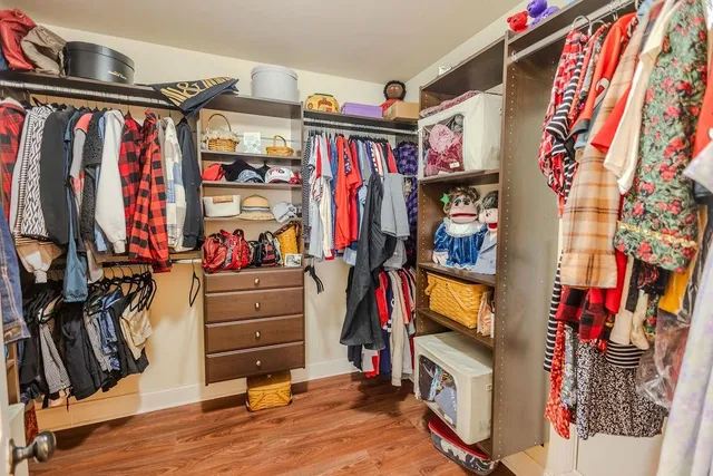 a view of walk in closet with clothes and shoes