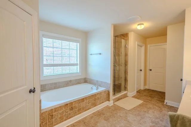 a spacious bathroom with a tub shower and a sink
