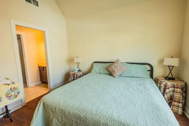 a bedroom with a bed and wooden floor
