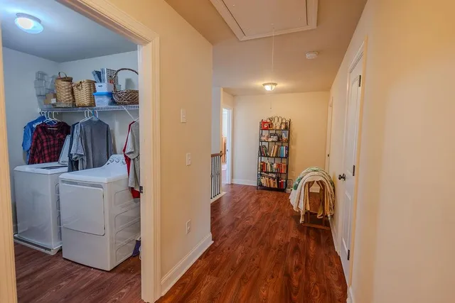 a view of a hallway with wooden floor and furniture