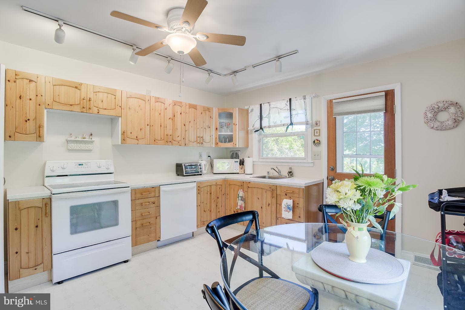 8414 Dogwood Road Baltimore, MD 21244 - Photo 20 of 29 a kitchen with stainless steel appliances kitchen island granite countertop a dining table chairs and white cabinets