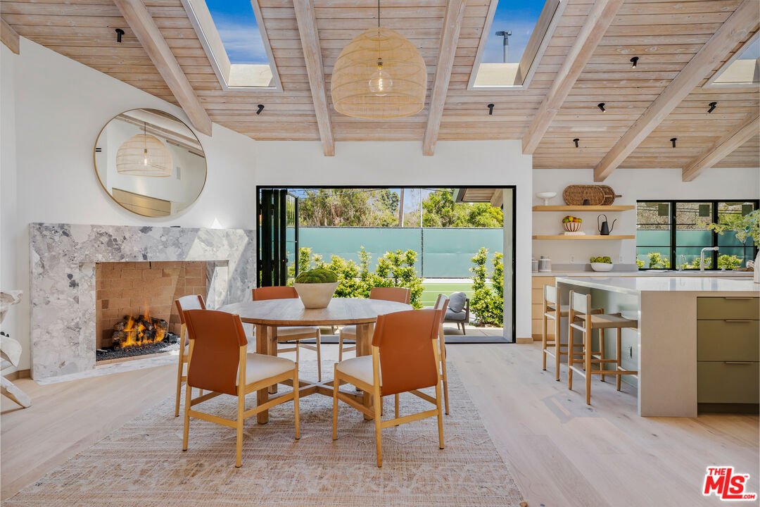 1508 Old Oak Road Los Angeles, CA 90049 - Photo 12 of 63 a view of a dining room with furniture a fireplace and wooden floor