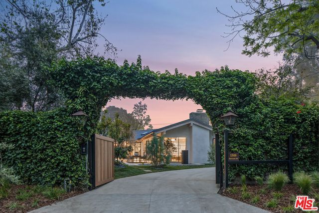 a front view of a house with a yard and trees