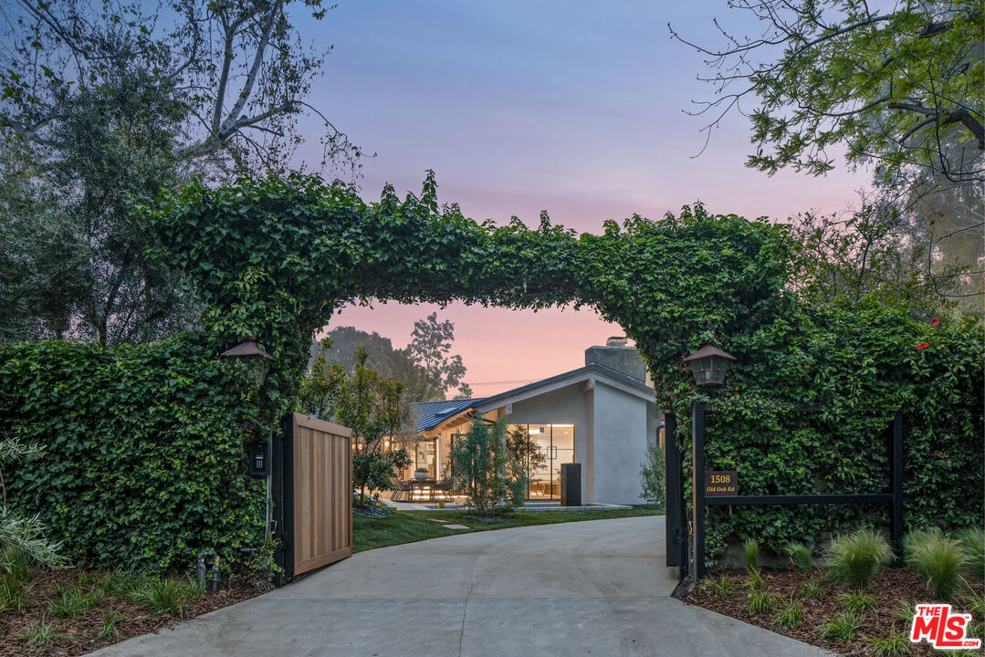 1508 Old Oak Road Los Angeles, CA 90049 - Photo 51 of 63 a front view of a house with a yard and garage
