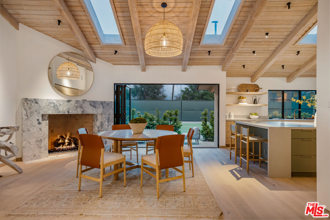 1508 Old Oak Road Los Angeles, CA 90049 - Photo 55 of 63 a dining room with furniture a fireplace and a large window