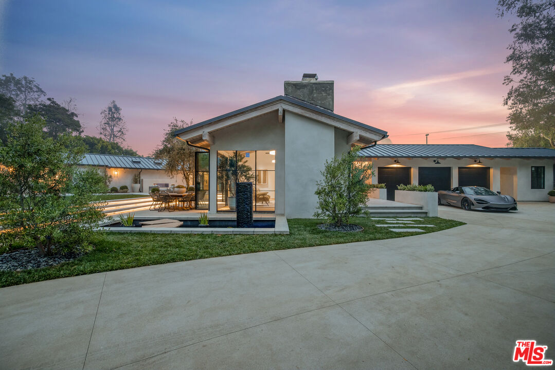 1508 Old Oak Road Los Angeles, CA 90049 - Photo 62 of 63 a front view of a house with a yard and trees