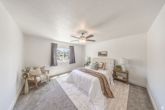 4991 South 475 West Washington Terrace, UT 84405 - Photo 21 of 31 LARGE primary bedroom. Neutral wall color, ceiling fan with light fixture, window with drapery, and carpeted flooring.