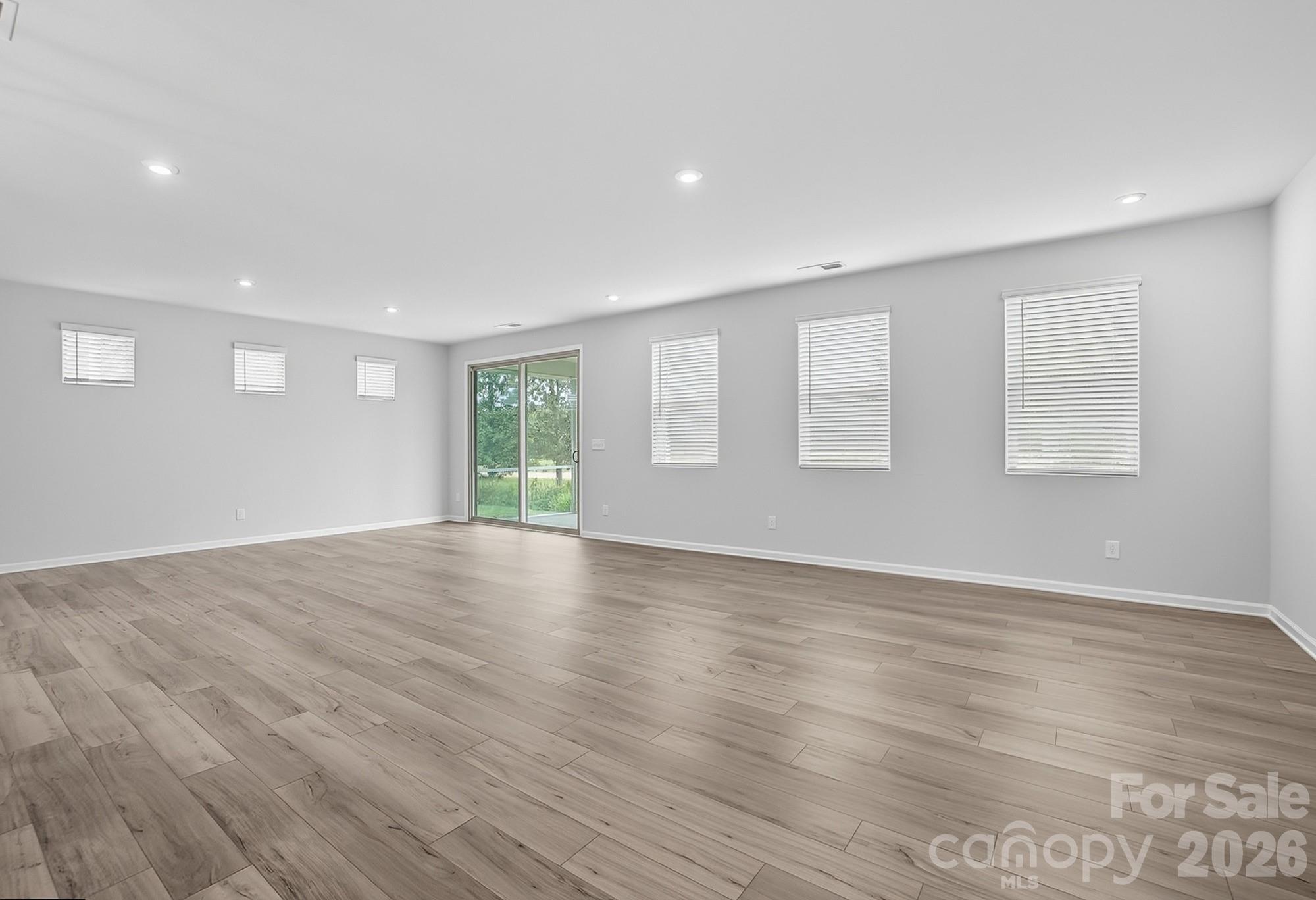 1505 Miriam Way Monroe, NC 28112 - Photo 11 of 29 an empty room with wooden floor and windows