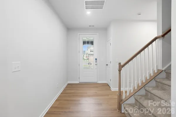 a view of a hallway with wooden floor and entryway