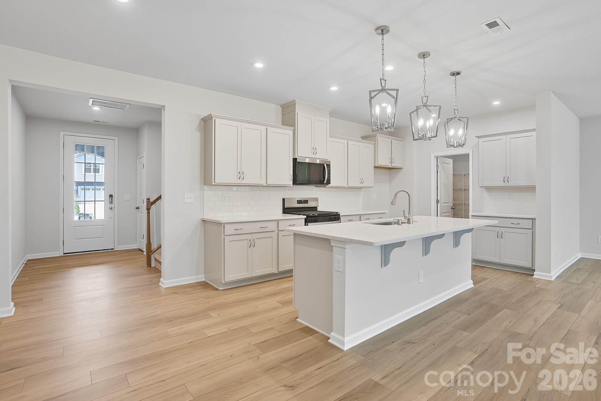 1505 Miriam Way Monroe, NC 28112 - Photo 5 of 29 a kitchen with kitchen island granite countertop a sink cabinets and wooden floor