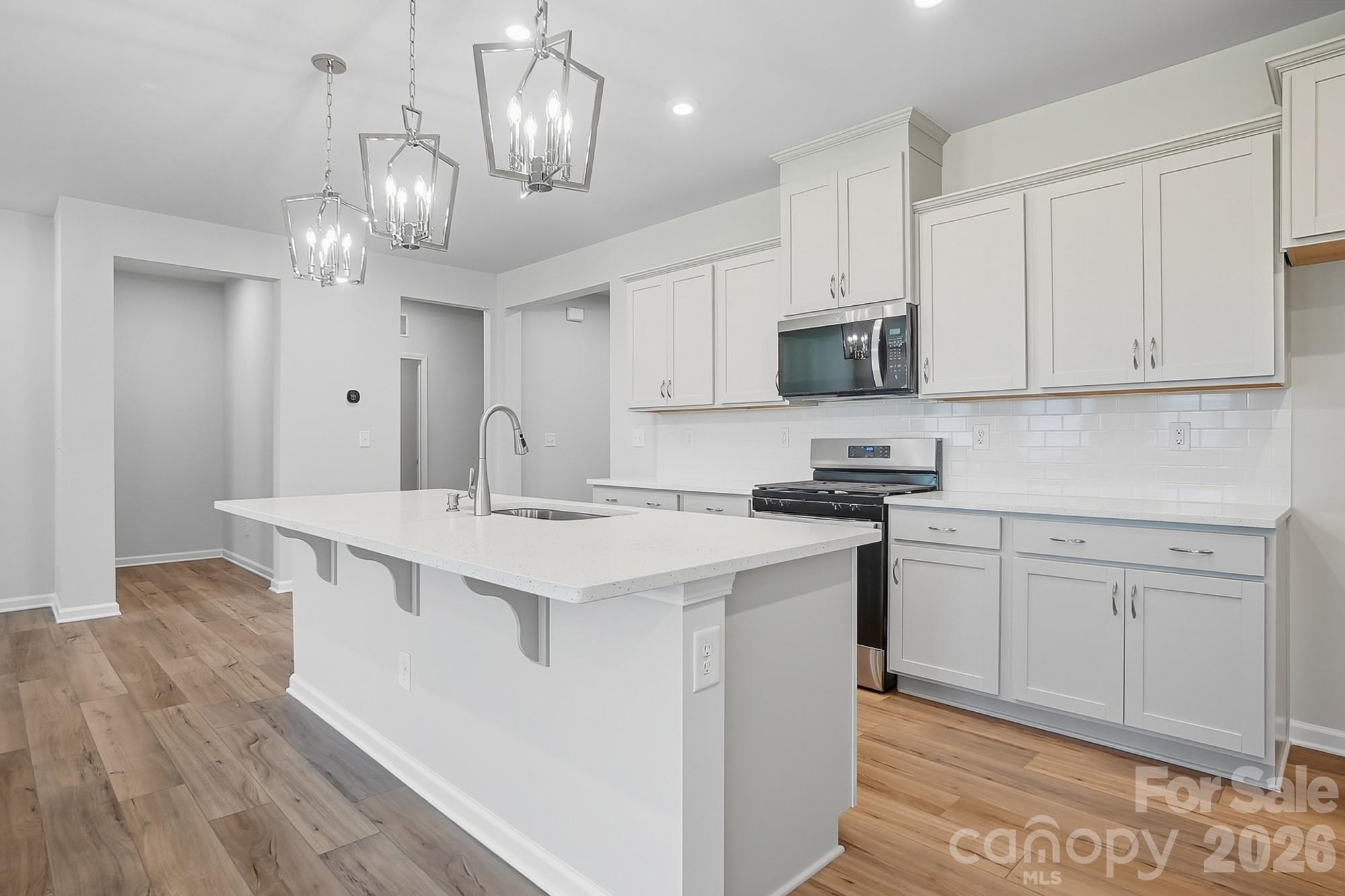 1505 Miriam Way Monroe, NC 28112 - Photo 7 of 29 a kitchen with kitchen island granite countertop a sink a stove and cabinets