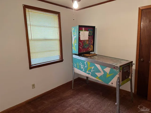 an empty room with a chandelier fan and windows