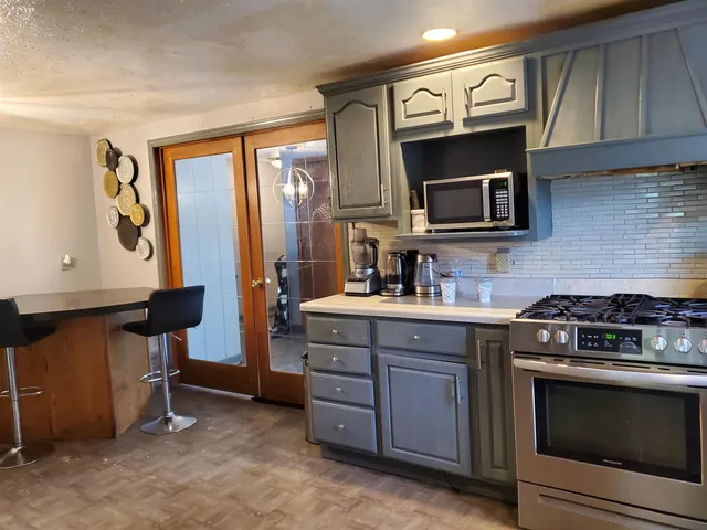 a kitchen with stainless steel appliances a stove microwave and cabinets