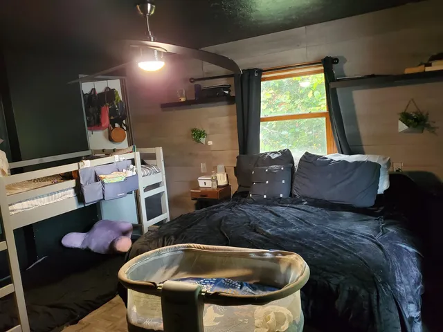 a bed sitting in a bedroom next to a window