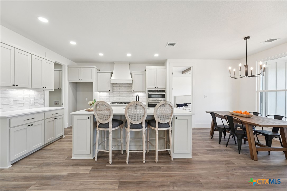 5207 Hollow Ranch Drive Salado, TX 76571 - Photo 11 of 37 a kitchen with cabinets a sink dining table and chairs