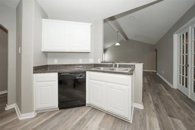 a kitchen with a stove cabinets and wooden floor