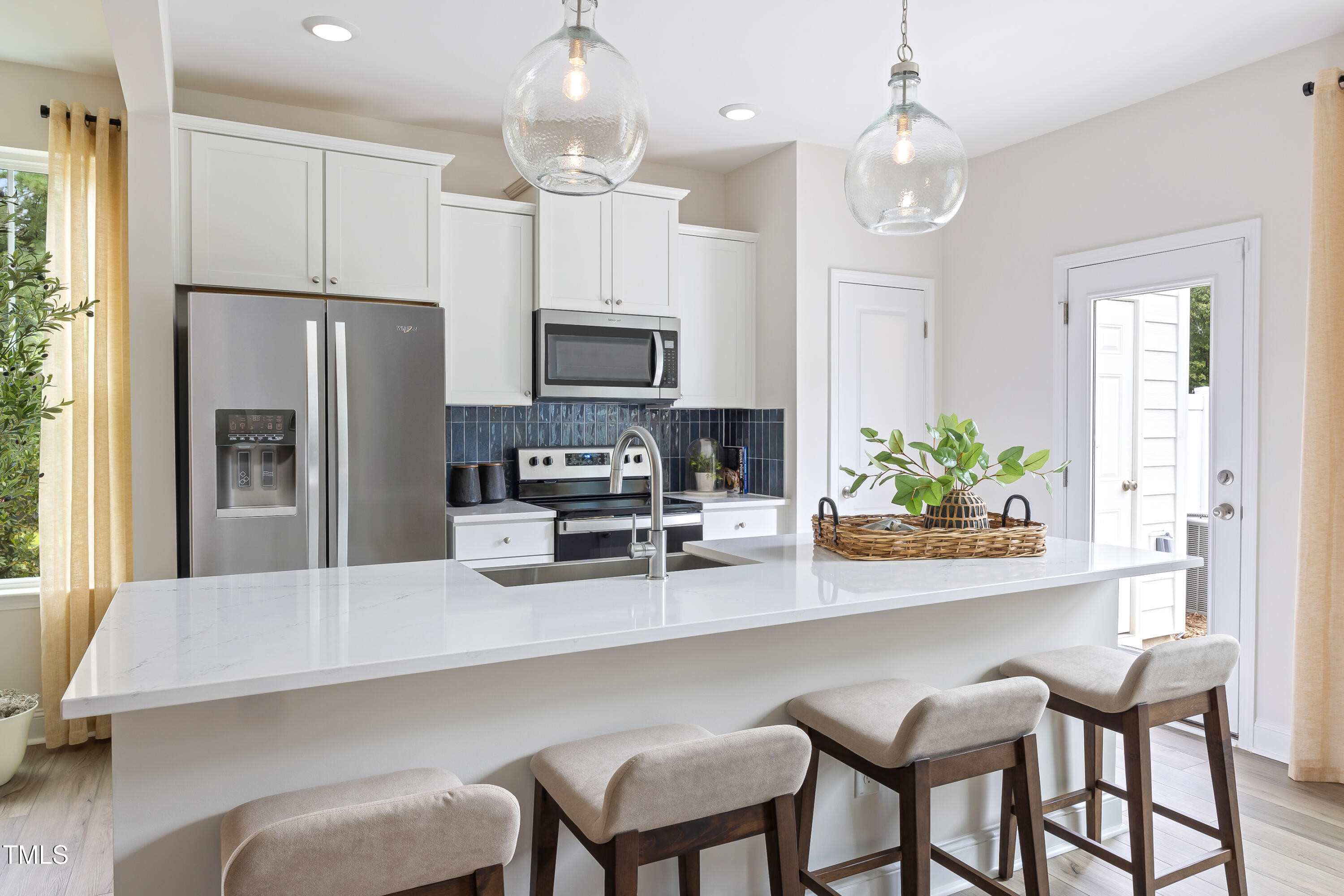 4973 Caddis Bend Raleigh, NC 27604 - Photo 26 of 29 a kitchen with stainless steel appliances a dining table chairs refrigerator and microwave