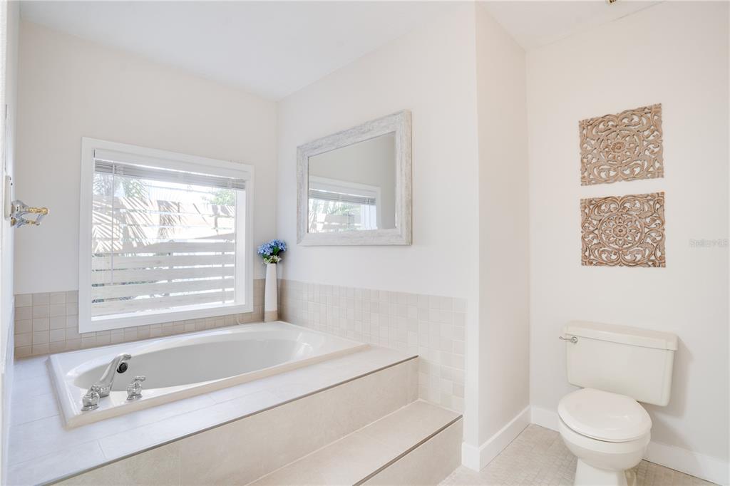 333 12th Avenue Indian Rocks Beach, FL 33785 - Photo 28 of 64 a bathroom with a granite countertop toilet a sink and a bathtub