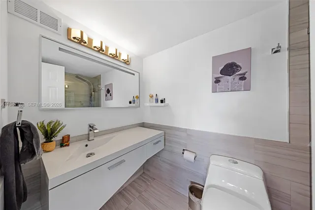 a spacious bedroom with a bed and a flat screen tv