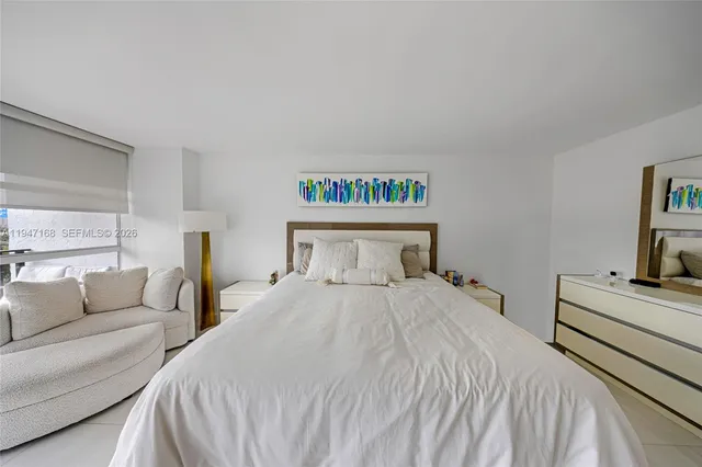 a bedroom with bed and a flat screen tv