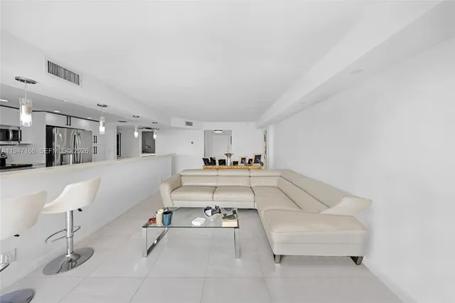 a large white kitchen with granite countertop lots of white stainless steel appliances