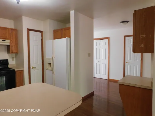 a kitchen with a refrigerator and a stove top oven
