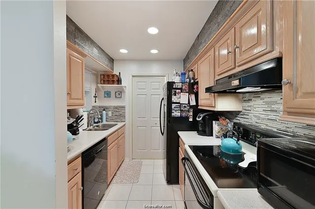 a kitchen with stainless steel appliances granite countertop a sink stove and cabinets