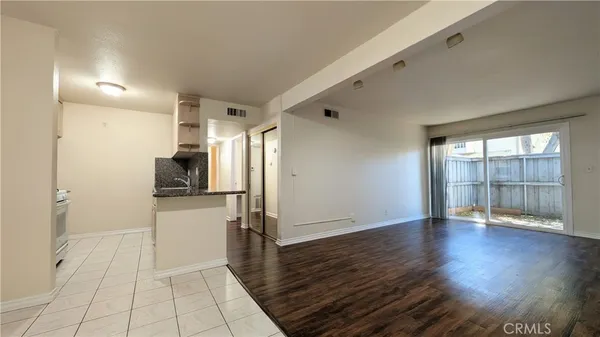 a view of a kitchen with wooden floor and a refrigerator