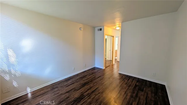 a view of an empty room and wooden floor