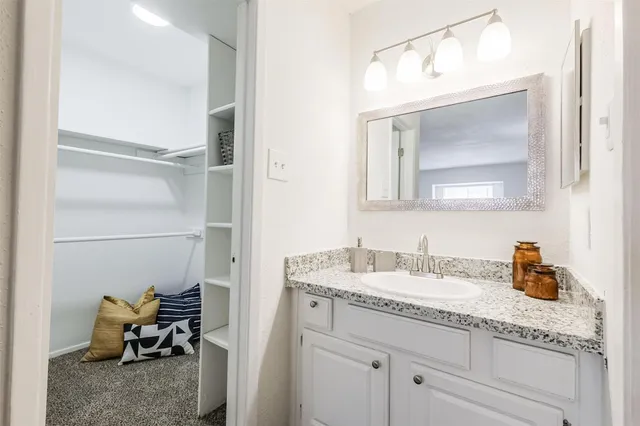 a en suite bathroom with a granite countertop sink and a mirror