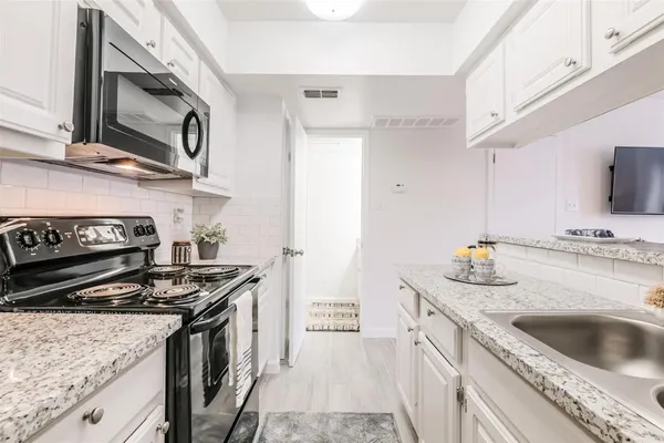 a kitchen with stainless steel appliances granite countertop a sink stove and refrigerator