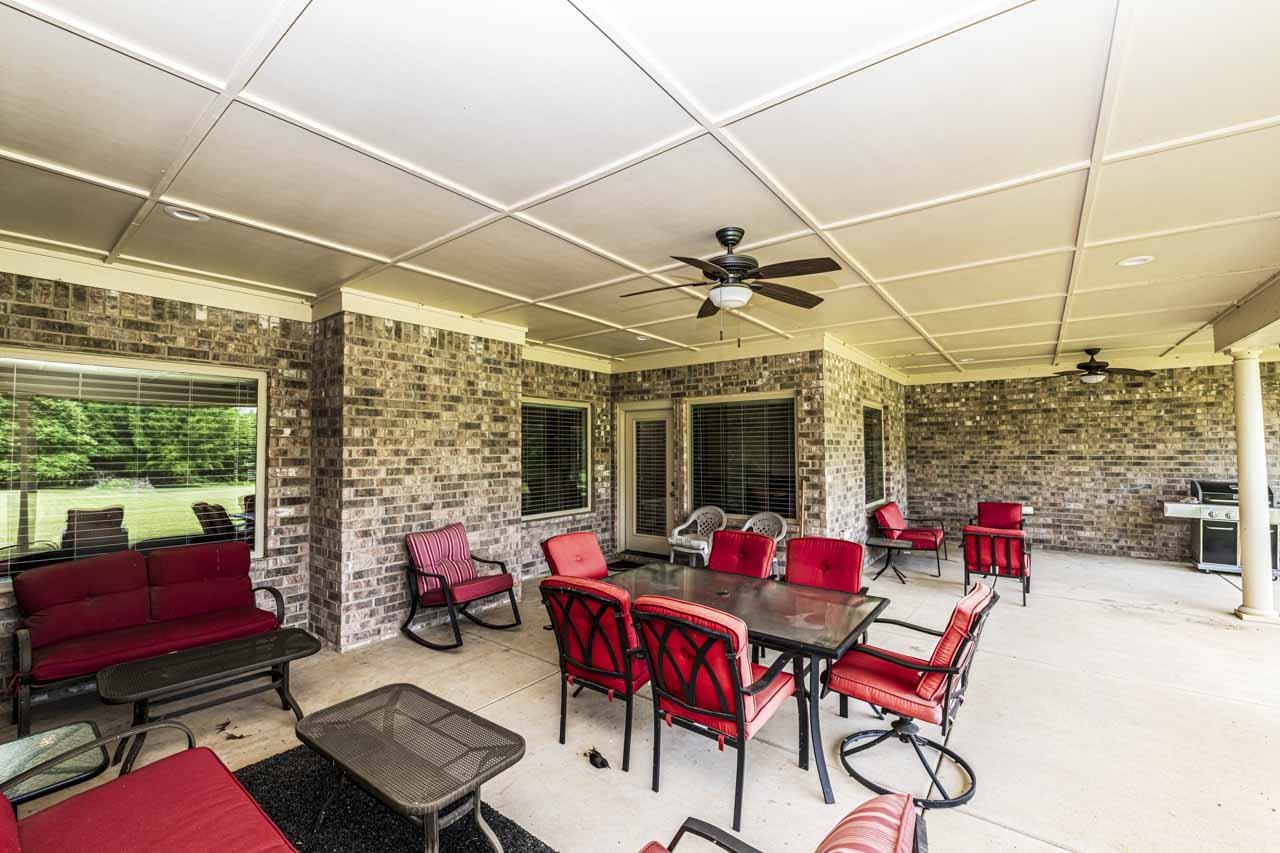 185 Belmont Road Mason, TN 38049 - Photo 4 of 38 Expansive covered patio featuring a coffered ceiling, multiple ceiling fans, brick exterior walls, and a concrete surface